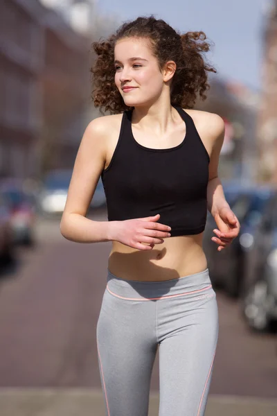Happy teenage girl jogging outdoors — Stock Photo, Image