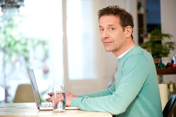 Laptop ile masaya oturan adam — Stok fotoğraf