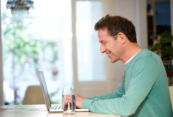 Homem feliz usando laptop em casa — Fotografia de Stock