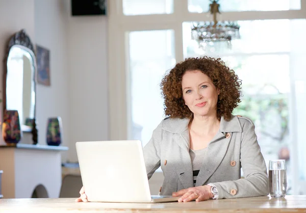 Mujer adulta usando computadora en casa — Foto de Stock