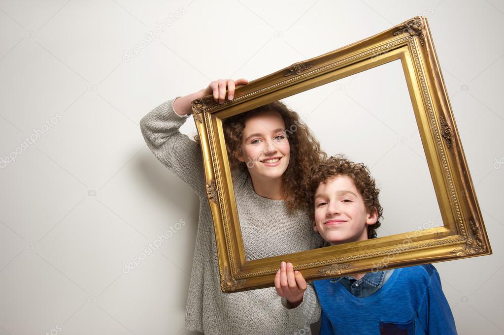 Happy brother and sister holding picture frame