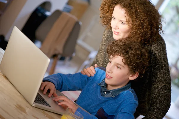 Mãe ajudando seu filho a usar o computador em casa — Fotografia de Stock