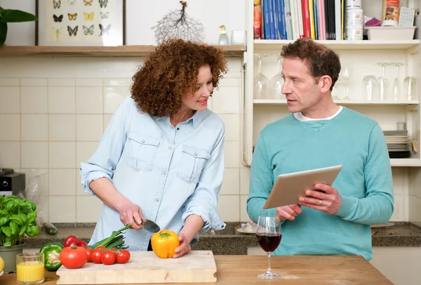 Муж и жена читают рецепт с планшета — стоковое фото
