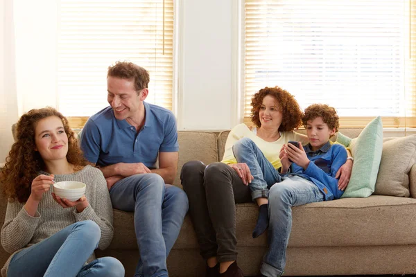 Lykkelig familie sidder derhjemme - Stock-foto