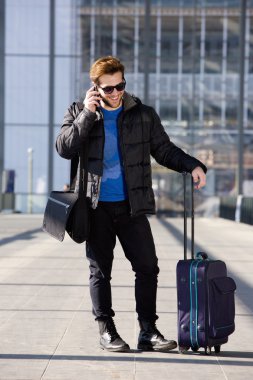 Havaalanında cep telefonunda konuşan mutlu seyahat adam