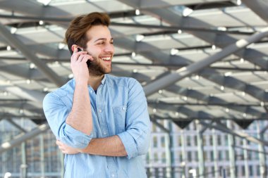 Gülümseyen adam cep telefonuyla konuşma zevk