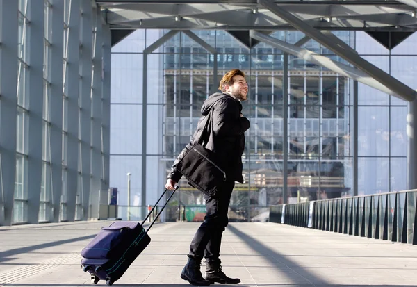 Gelukkig jonge man met koffer op station wandelen — Stockfoto