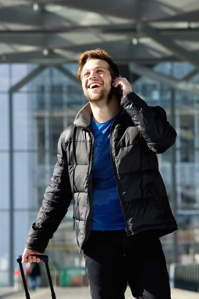 Счастливый привлекательный мужчина ходит и разговаривает по мобильному телефону — стоковое фото