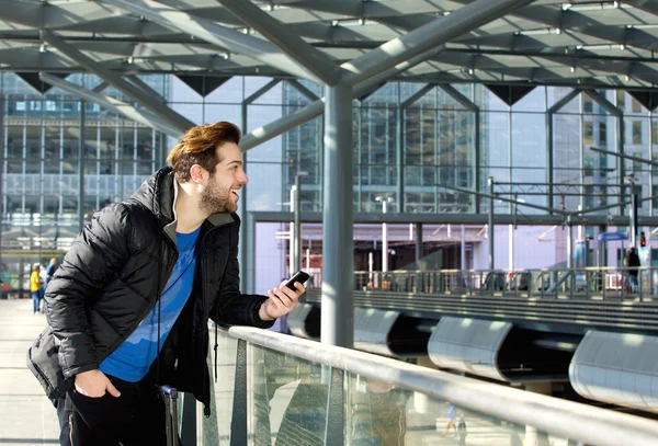 Cooler Typ steht mit Handy am Bahnhof — Stockfoto