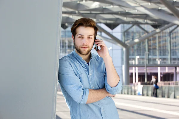 Stilig ung man med skägg ringer genom mobiltelefon — Stockfoto