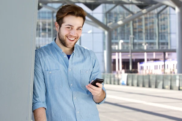 Крутой парень улыбается с мобильного телефона — стоковое фото