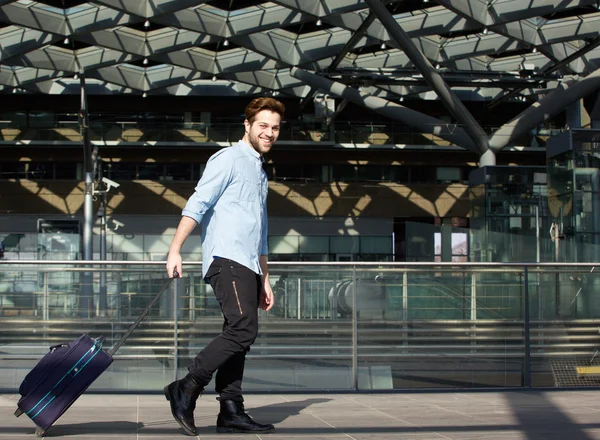 Sorrindo viajante masculino andando com mala — Fotografia de Stock