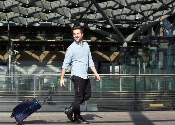 Feliz viajero masculino caminando con la maleta —  Fotos de Stock
