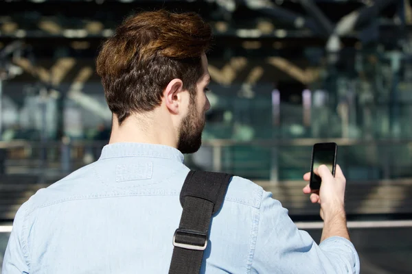 Jovem viajando homem ler mensagem de texto no telefone móvel — Fotografia de Stock