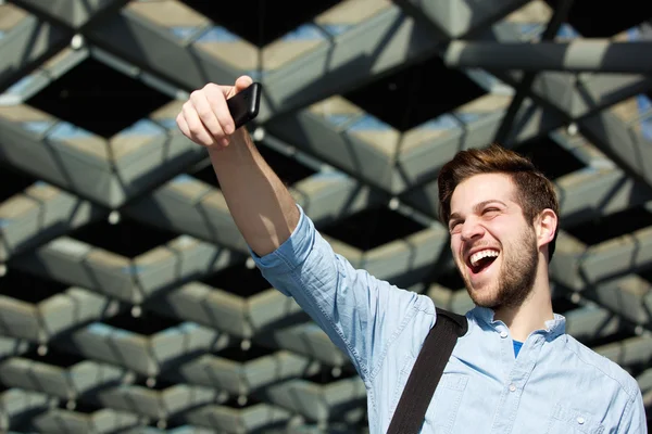 Jovem alegre tomando selfie — Fotografia de Stock