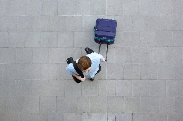 Young man walking with luggage at airport