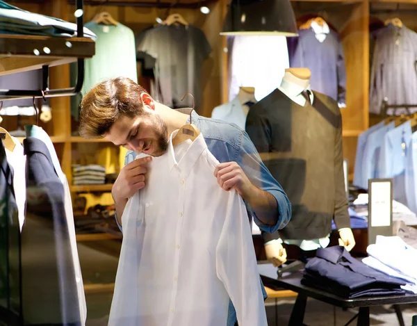 Bonito jovem comprando roupas — Fotografia de Stock