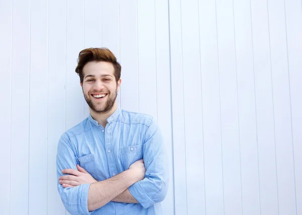 Aantrekkelijke jonge man die lacht met gekruiste armen — Stockfoto
