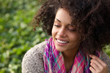 Kendine güvenen genç Afro-Amerikan kadın gülümseyerek 