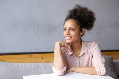 Kapalı gülümseyerek oturan çekici genç kadın