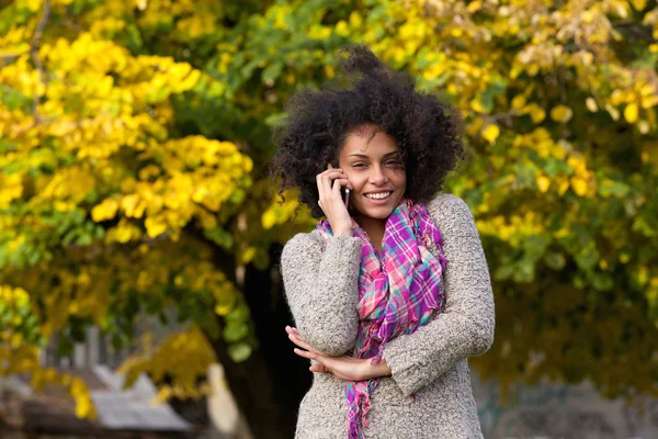 Feliz mujer de raza mixta hablando en el teléfono móvil al aire libre —  Fotos de Stock