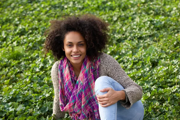 Gelukkige vrouw zitten op gras buiten — Stockfoto