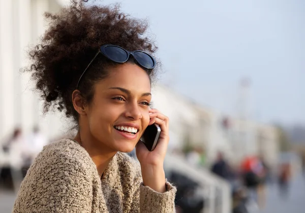 Aantrekkelijke jonge vrouw glimlachend en praten op mobiele telefoon — Stockfoto