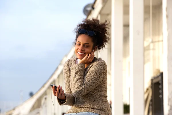 Mujer escuchando en los auriculares desde el teléfono móvil —  Fotos de Stock