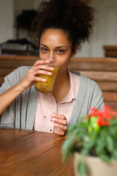 Junge afrikanisch-amerikanische Frau trinkt Orangensaft — Stockfoto