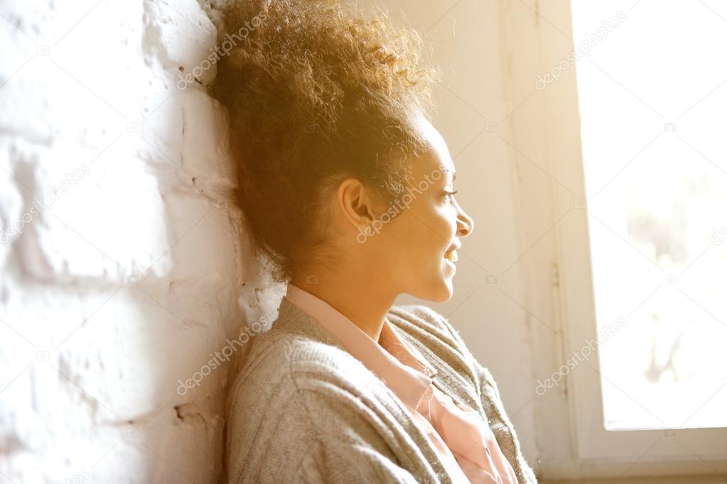 African american woman smiling and looking out of window