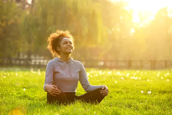 Felice giovane donna seduta in posizione yoga — Foto Stock