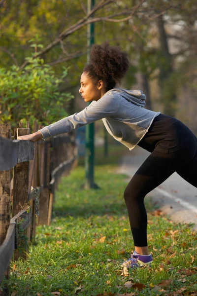 Donna attiva che allunga i muscoli all'aperto — Foto Stock