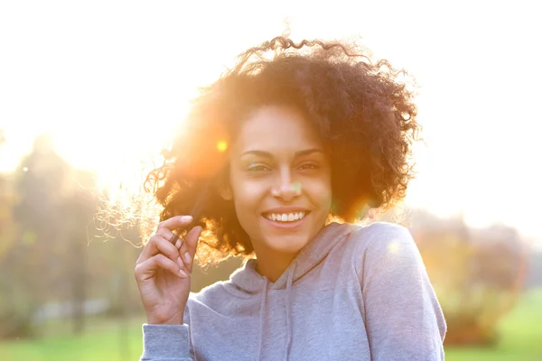 Glimlachend jonge zwarte vrouw met krullend haar — Stockfoto