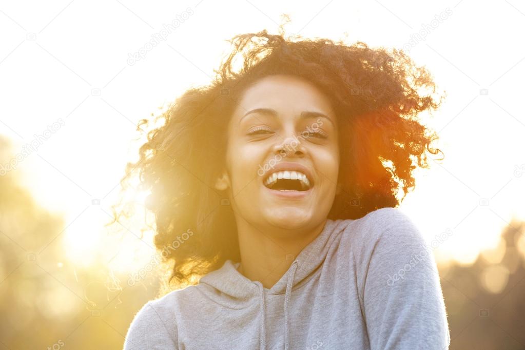 Happy young woman laughing outdoors