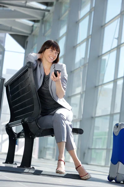 Allegra donna d'affari seduta con il cellulare — Foto Stock