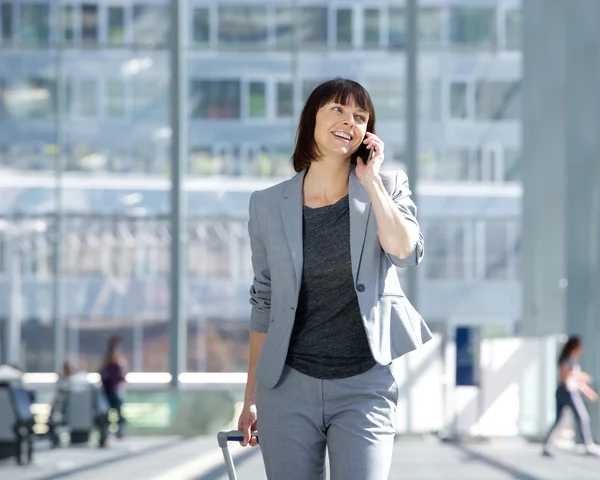 Lopend en pratend met mobiele telefoon op luchthaven — Stockfoto