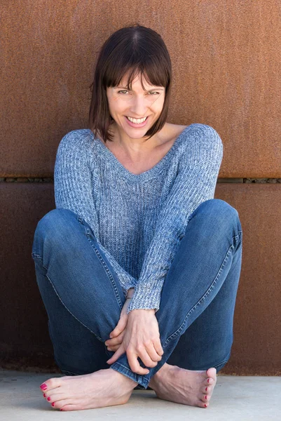 Mujer despreocupada sentada y sonriente — Foto de Stock