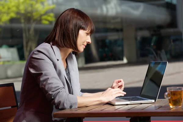 Zakenvrouw met behulp van laptop in café tijdens pauze — Stockfoto