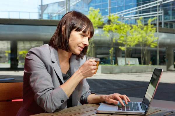 Mujer de negocios que trabaja en el ordenador portátil en la cafetería al aire libre —  Fotos de Stock
