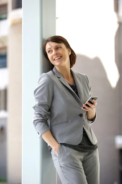 Mujer de negocios profesional de pie con teléfono móvil —  Fotos de Stock