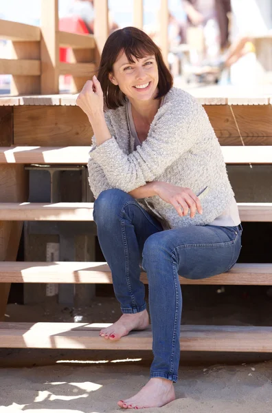 Attractive happy woman sitting on steps outside — Stock Photo, Image