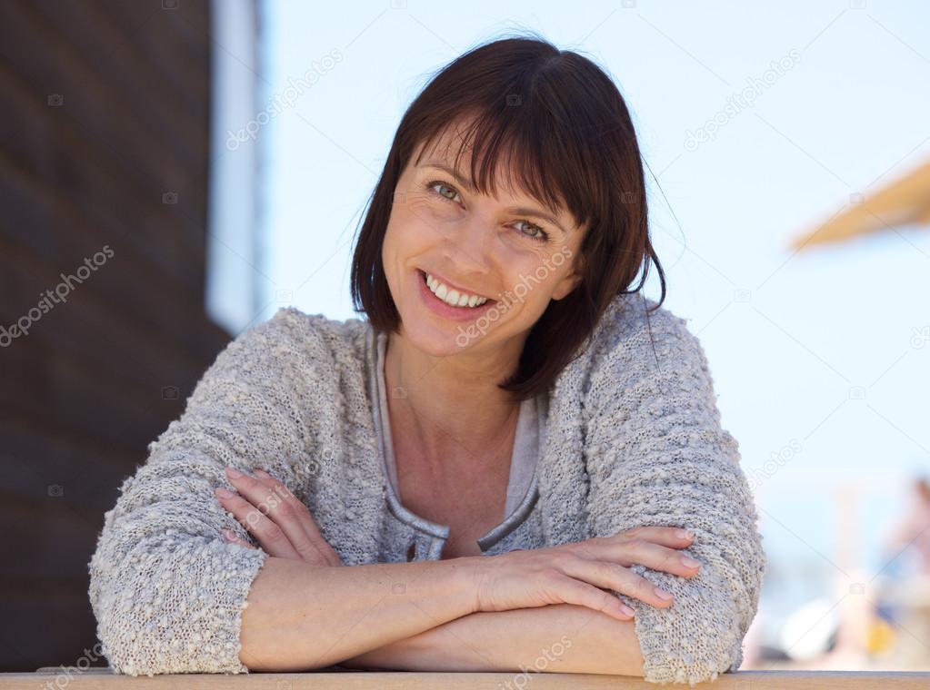 Confident middle aged woman smiling outside