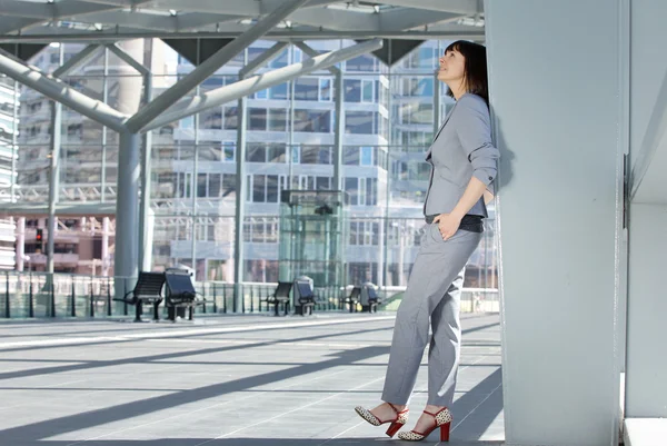 Business woman standing inside city building — Stockfoto