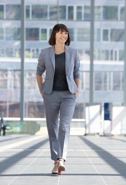 Relaxed business woman smiling and walking 