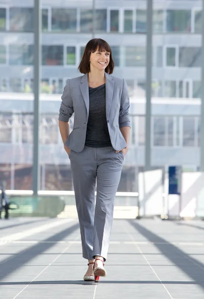 Relajada mujer de negocios sonriendo y caminando —  Fotos de Stock