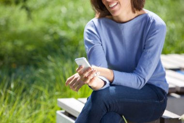 Parkta cep telefonu kullanan bir kadın.