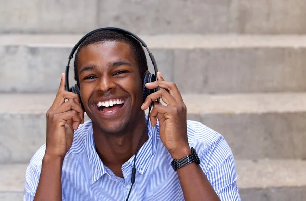 Homem americano africano feliz rindo com fones de ouvido — Fotografia de Stock