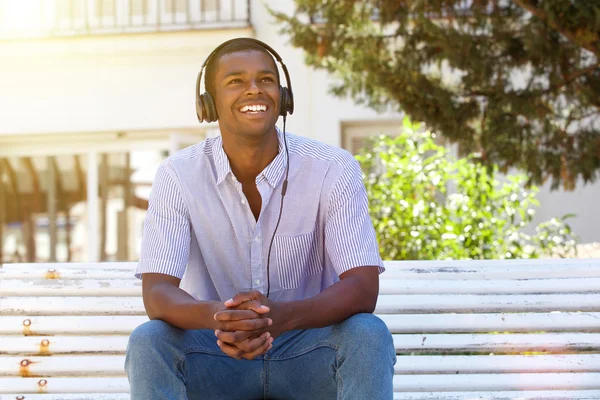 Young man smiling outside with headphones — Stock Photo, Image