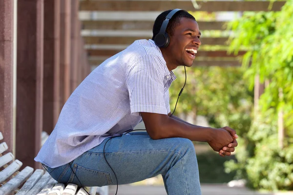 Cool chico riendo con auriculares en el parque —  Fotos de Stock