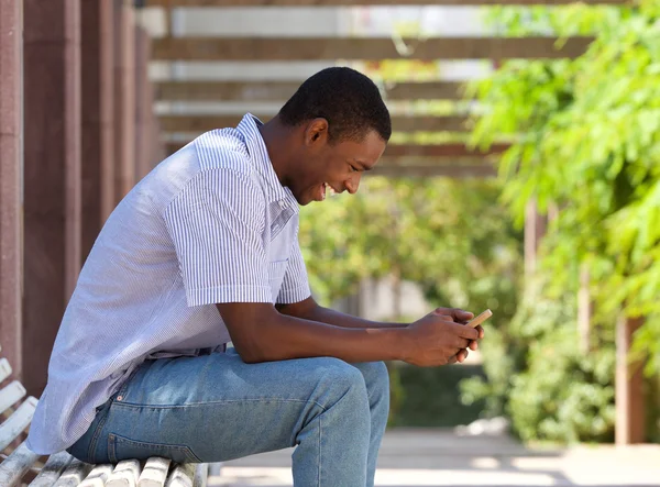 Cool афро-американських хлопця дивлячись на мобільний телефон — стокове фото